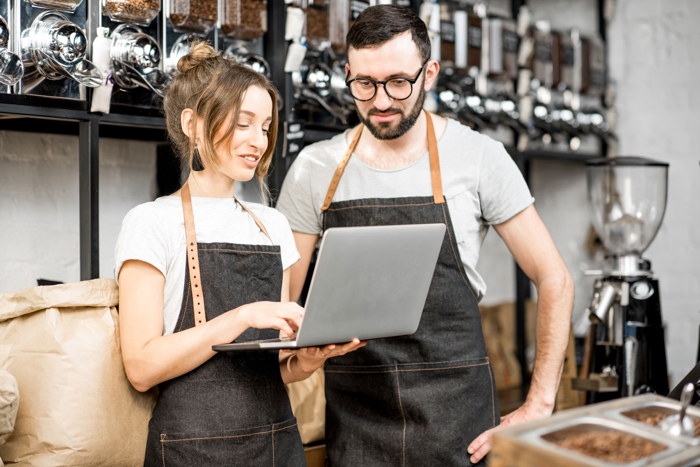 Man and woman looking at laptop together in roastery