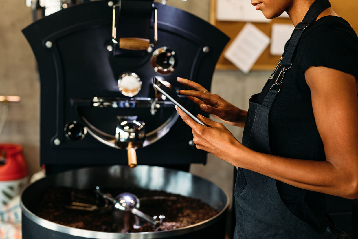 Woman with tablet at roasting machine
